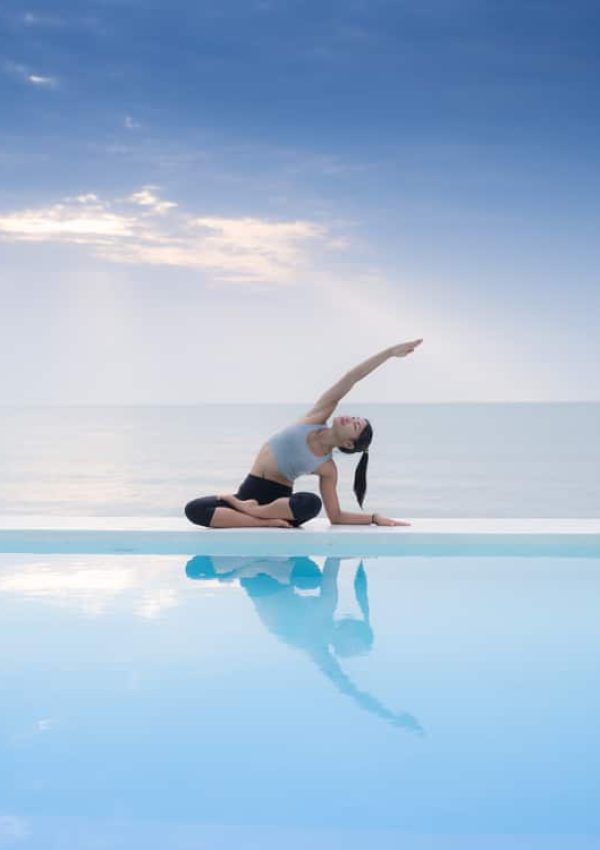 Woman doing yoga poolside at luxury villa in turks and caicos